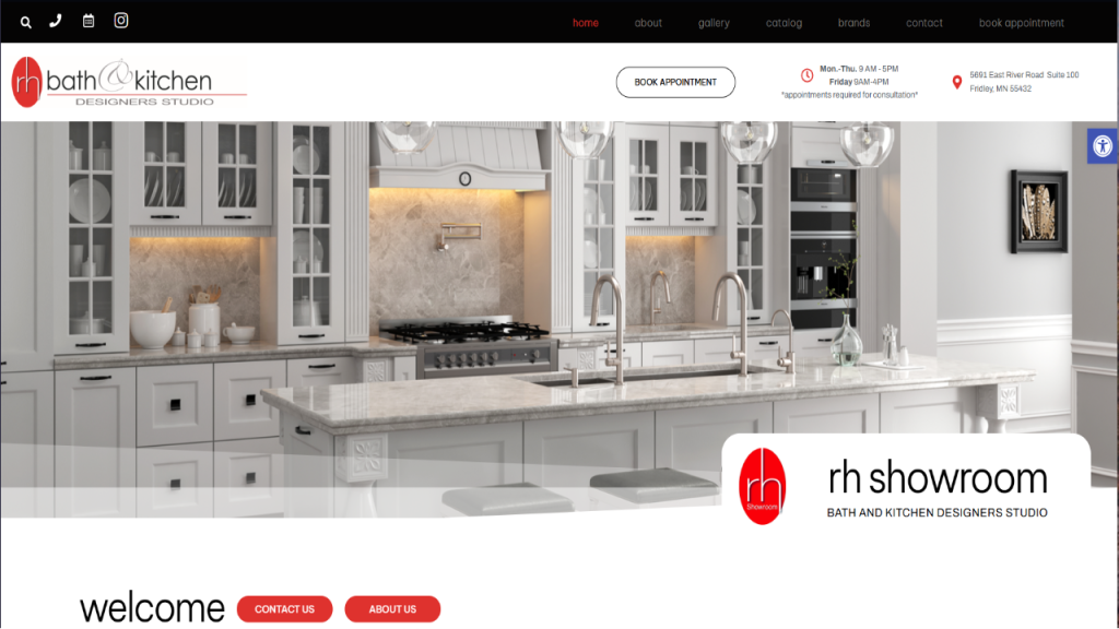 A modern kitchen showroom featuring a large white marble island with a sink and stainless steel faucet. Behind it, cabinetry and appliances are neatly arranged against a light wall. The design reflects web design for plumbing showroom aesthetics.