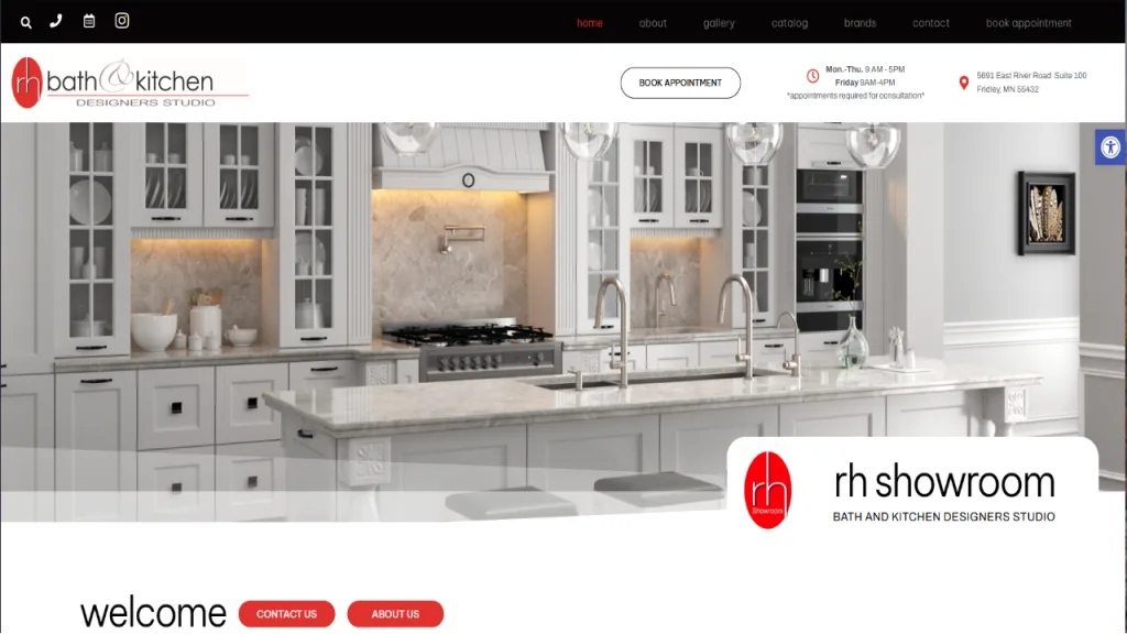 A modern kitchen showroom featuring a large white marble island with a sink and stainless steel faucet. Behind it, cabinetry and appliances are neatly arranged against a light wall. The design reflects web design for plumbing showroom aesthetics.